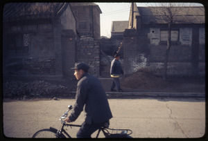 Houses -- woman carrying basket, man on bicycle