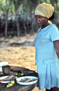 Haitian woman cooking fish