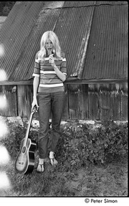 Karen Helberg eating a popsicle and holding a guitar