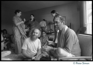 Ram Dass and others seated on the floor at the feet of Swami Muktananda