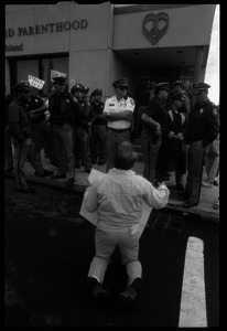 Pro-life protester on his knees, facing a line of police in front of the Providence Planned Parenthood clinic