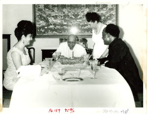 W. E. B. Du Bois cutting his 95th birthday cake with Shirley Graham Du Bois, President Kwame Nkrumah and Madame Nkrumah