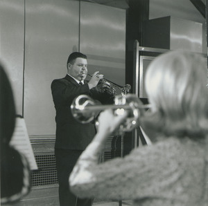 Walter Chesnut playing trumpet, in front of a woman playing trumpet