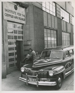 A Red Cross volunteer pushes a woman in a wheelchair into the ICD building