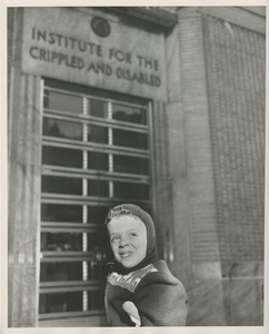 David Grierson, a young boy on crutches, in front of an ICD building