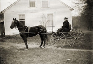 Man in a carriage, with horse, dressed for cold weather (Greenwich, Mass.)