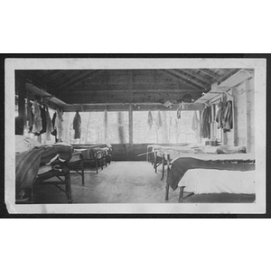 View of cabin interior with beds and hanging clothes