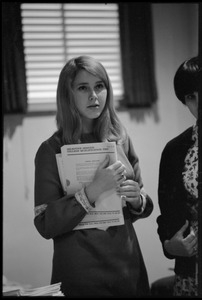 Young woman distributing tests at the Selective Service College Qualification examination to determine eligibility for an educational deferment from service in the Vietnam War