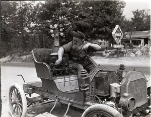 Charles Coffin, The Maine Hermit, seated in an old Brush automobile with mechanical gadget