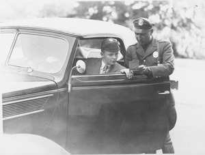 Campus police officer Tom Moran showing a violation to a student in their car
