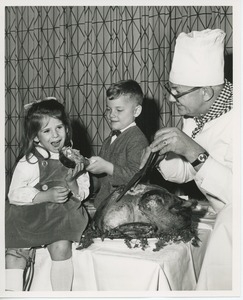 Chef carving turkey for young clients at Thanksgiving dinner