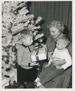 Young boys and older woman with presents and Christmas tree