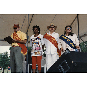 Four people stand on stage at the Festival Puertorriqueño