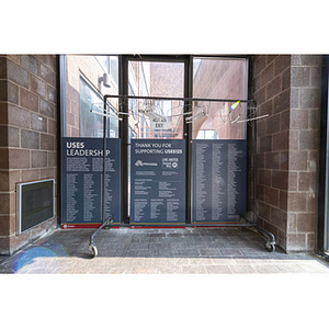 Harriet Tubman House leadership and donor signage behind a coat rack
