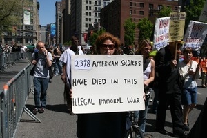 Marcher carrying sign reading ''2398 American soliders have died in the illegal immoral war,' during the protest against the war in Iraq