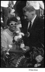 Robert Kennedy and Kenneth Keating campaigning in Riverdale: Andrea Simon holding flower bouquet with unidentified man