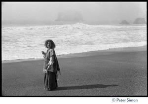 Usha (Cathy Brown) on the beach, the surf in the background