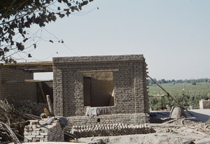 Building an adobe house on farmland