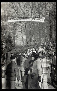 Large crowd gathered to greet the Iran hostages at Highland Falls, N.Y., beneath banner reading 'Welcome home'