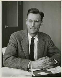 Edward A. Buck sitting behind desk indoors