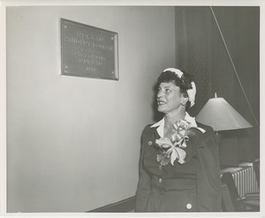 Woman looks at newman student lounge plaque