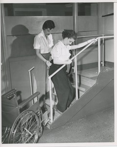 Physical therapist helping young woman on stairs