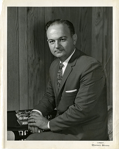 Charles R. Santos posing with books