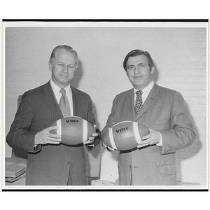 Frederick J. Davis, on the right, and an unidentified man, holding footballs at a fund-raising event for the Boys' Clubs of Boston