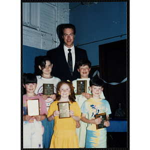 Former Boston Celtic Dave Cowens posing for a group picture with five boys and girls at a Kiwanis Awards Night