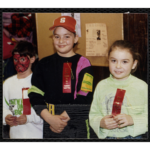 A boy with his face painted, another boy, and a girl wear "DRUG FREE AND PROUD TO BE" ribbons and pose together at a joint Charlestown Boys and Girls Club and Charlestown Against Drugs (CHAD) event