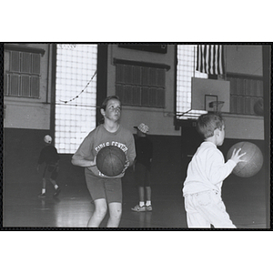 A girl holding a basketball and standing in shooting position during the Boys and Girls Clubs of Boston 100th Anniversary Celebration event at the Charlestown Boys and Girls Club gymnasium