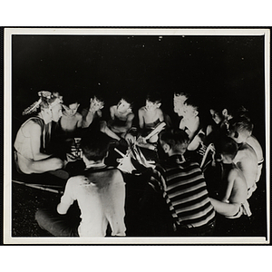 Members of the Indians club seated in a circle and listening to a story