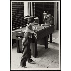 Two boys playing a game of bumper pool
