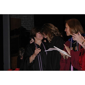 A student and Pamela D. Gorgone, another student, hug at the School of Nursing convocation