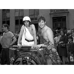 Two students at a fraternity chariot race in the quadrangle