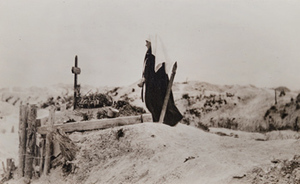 Red Cross worker next to a grave marked with a cross and a wreath, Fort de la Pompelle