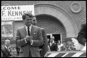 Robert F. Kennedy applauds the turkey (far right) at the Turkey Day festivities (Walter Mondale in the background)