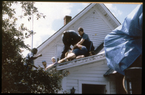 State troopers arresting a protester on the roof of the home of war tax resisters Randy Kehler and Betsy Corner