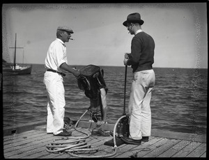 William F. Clapp and associate adjusting a diver's helmet at dockside