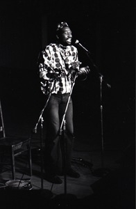 Taj Mahal in concert at Northfield, Mass.: Taj Mahal singing at microphone