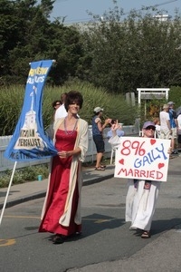 Parade marchers with banner for the Unitarian Universalist meetinghouse and sign celebrating same sex marriage : Provincetown Carnival parade