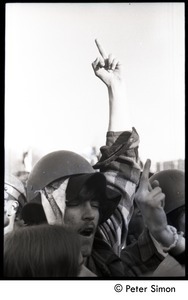 Protester in military helmet raising his middle finger
