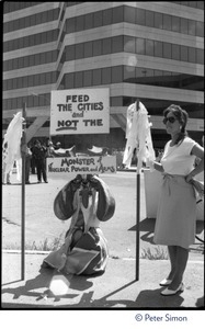 Protester associated with Mobilization for Survival at an antinuclear demonstration near Draper Laboratory, MIT, carrying a sign reading 'Feed the cities and not the monster of nuclear power and arms'