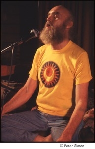 Ram Dass singing, on stage with Amazing Grace