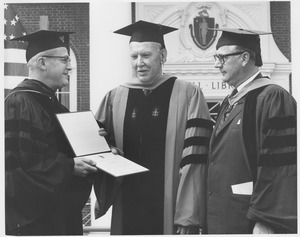 Hans Christian Duus standing outside of Goodell with two men at Commencement