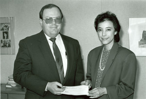 Deirdre Ling standing indoors with an unidentified man