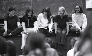 Women's liberation lecture at Boston University: women on foot of stage, Sue Katz speaking