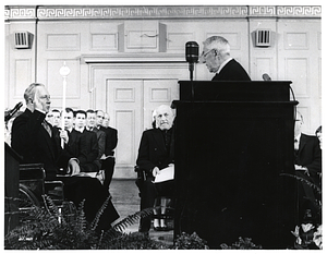 Unidentified justice swearing in Mayor John F. Collins at Symphony Hall, with Cardinal Richard Cushing seated behind podium