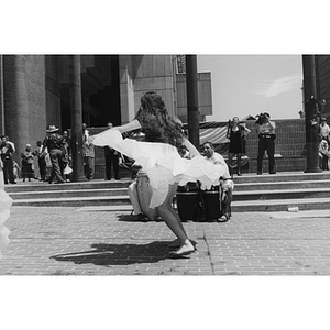 A girl lifts her skirt as she dances at Boston's City Hall Plaza