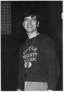 Suffolk University Athletics Director James E. Nelson (1978-2013), with whistle and "Suffolk University Athletic Dept." sweatshirt